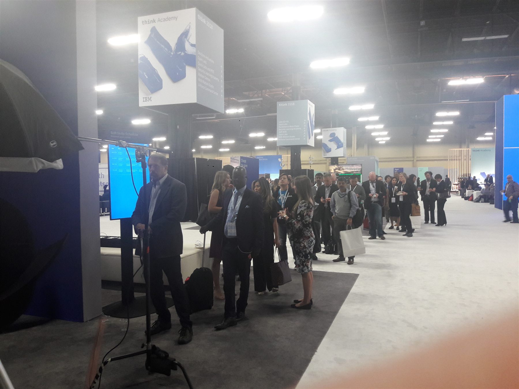 Professionals lined up at a technology company trade show booth headshot lounge